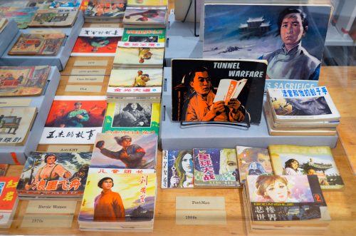 Vintage Chinese lianhuanhua comics display, propaganda booklets incl. Tunnel Warfare, museum exhibit 1970s–1980s.