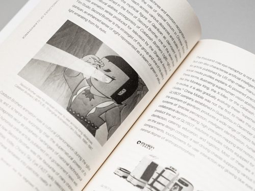 Open book with text and black-and-white cartoon illustration of a boy shooting a light beam from his eyes, close-up